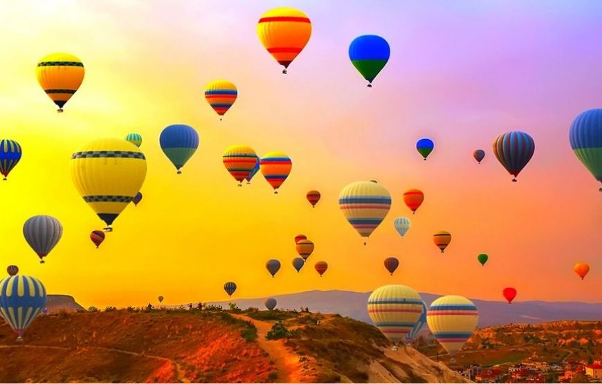 Hot air balloons floating over Cappadocia's surreal landscapes at sunrise.