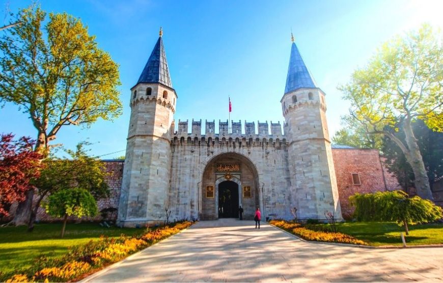 Exterior view of the Second Gate of Topkapi Palace in Istanbul, Turkey, featuring ornate architecture and towering walls.