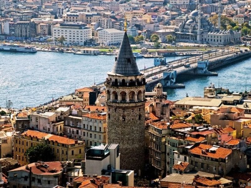 The historic Galata Tower in Istanbul, illuminated against the sky.