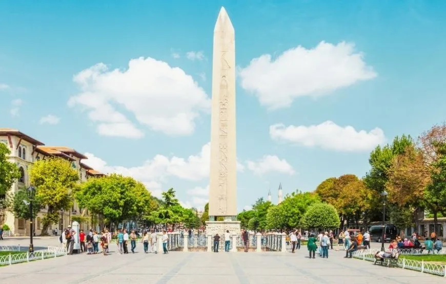 The Obelisk of Theodosius at the ancient Hippodrome in Istanbul, surrounded by a historical square.