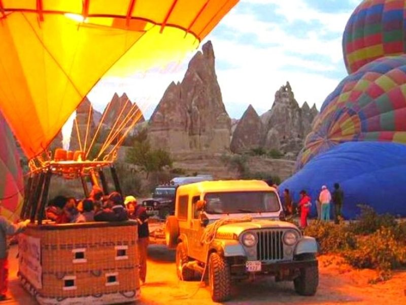 Hot air balloon launching in Cappadocia, with colorful balloons against the early morning sky
